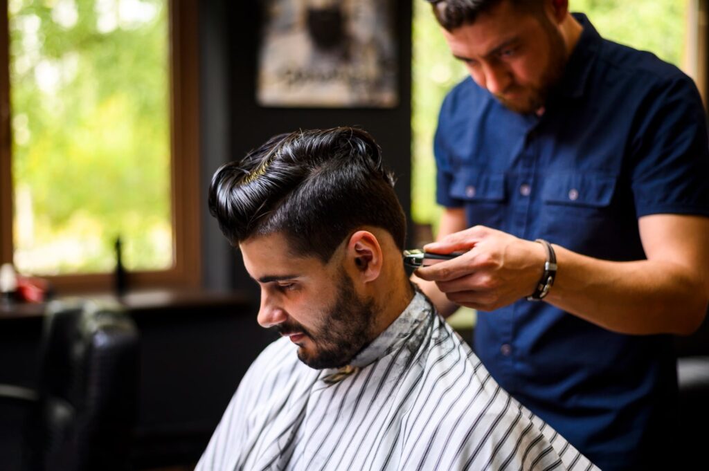 medium shot barber giving client new hairstyle discovering the price for mens haircut and beard trim