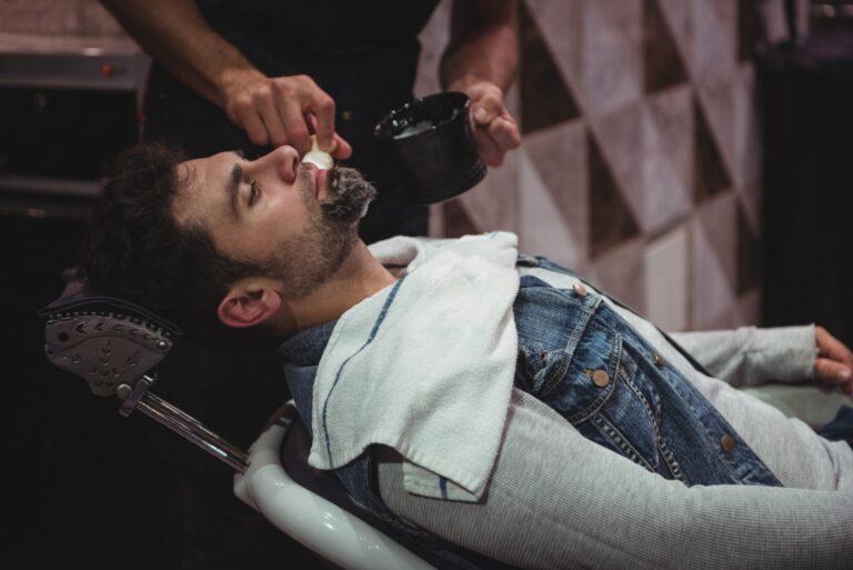 mid section barber applying cream clients beard for a barber shave