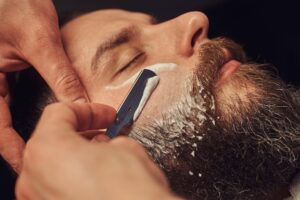 professional hairdresser modeling beard barbershop close up photo of a hot shave barber