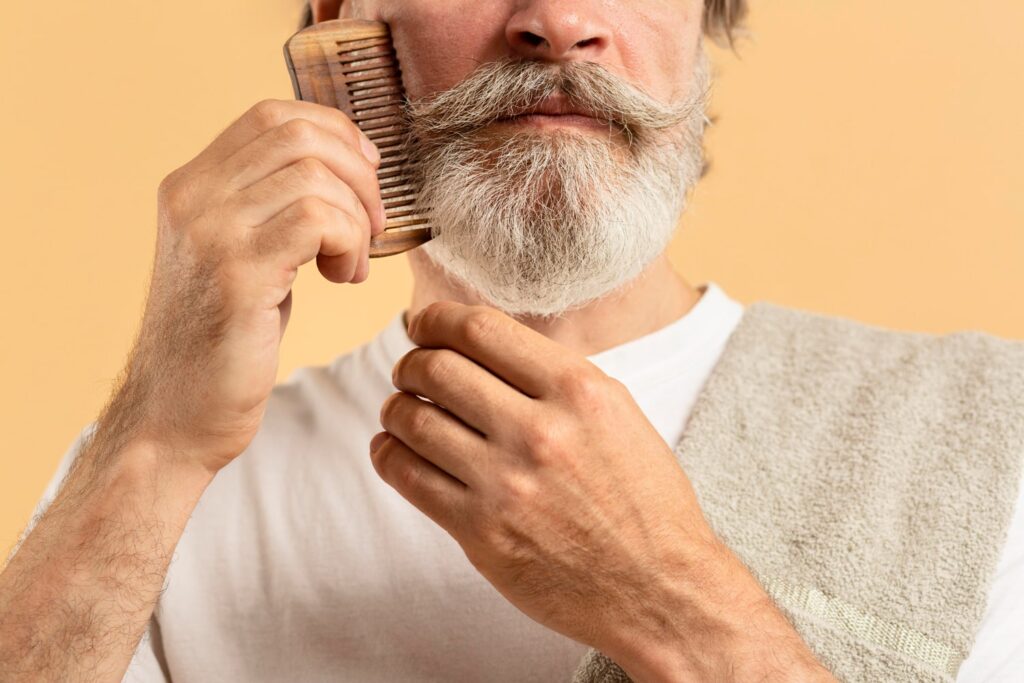 elder man with towel combing his beard to explain whtn to use a beard brush vs comb
